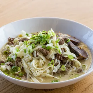a bowl of noodles with meat and vegetables