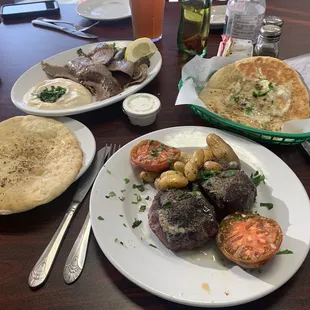 Clockwise from bottom right: filet mignon, homemade pita, the Greek Sampler Plate, and more homemade pita with a garlic sauce
