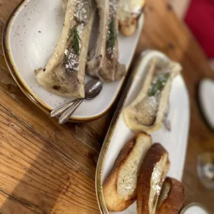 Fire roasted extra-long bone marrow canoe with cotija cheese, served with crostini