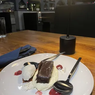 Flourless chocolate cake with ice cream, whipped cream, coconut, raspberry sauce.