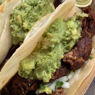 two tacos with guacamole and lime