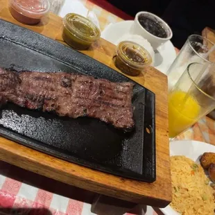 a large steak on a black plate