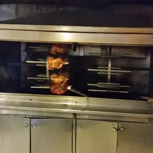 Rotisserie / Smoker was busy twirling with chickens. They were loading other meats on the right side of the smoker.