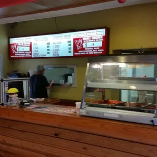 The menu on the wall behind the counter is for the old restaurant. The new menu is *ON* the counter next to the cash register.