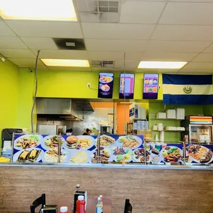 Order counter with menu on screens and also blown up pictures of some of the menu items.