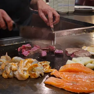 a chef preparing food on a grill