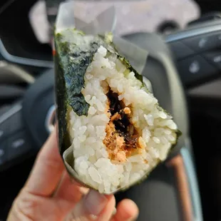 a person holding a piece of sushi
