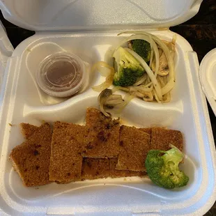 a styrofoam container with a variety of food items