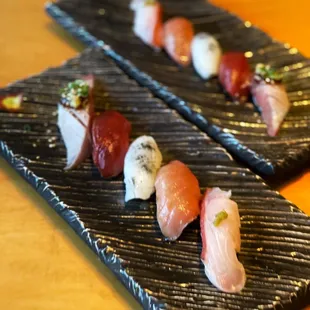 two plates of sushi on a wooden table