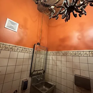 Restroom is like a gas station with a South of the Border paint job and chandelier