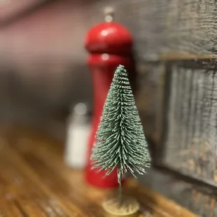 a miniature christmas tree and pepper shakers