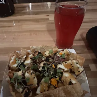 a plate of nachos and a glass of beer