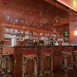 a bar with stools and wine glasses