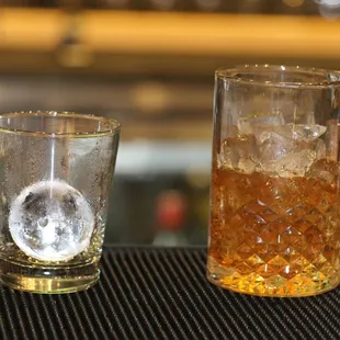 a glass of ice and a shot of whiskey