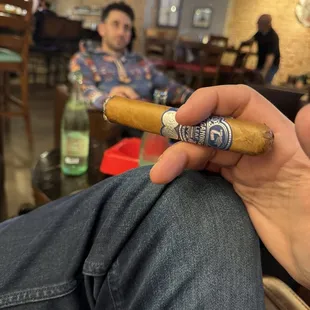 a hand holding a cigar