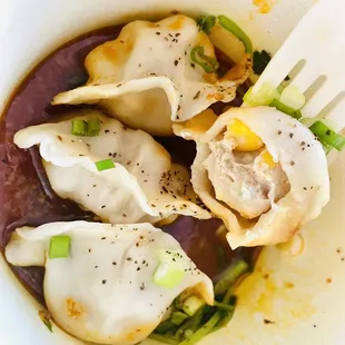 a bowl of dumplings and a fork
