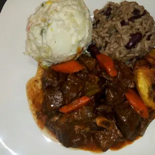 Stewed Goat served with Vegan Potato Salad, Red Beans and Rice and Plantain.