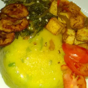 Organic Tofu   in a Red Creole Sauce served over Turnmeal and Okra with  Tomato Slices,  Okra and Spinach Medley and Plantain.