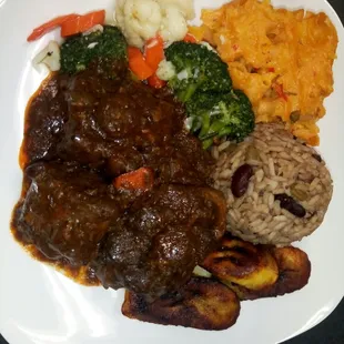 Halal Stewed Oxtail served with Baked Vegan Macaroni and Cheese, Mixed Vegetables, Red Beans and Rice and Plantain.