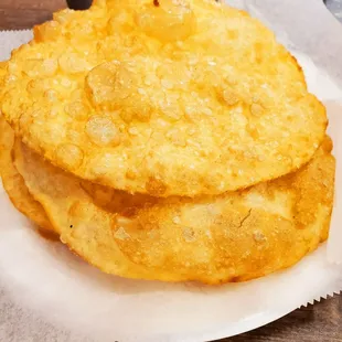 a stack of fried bread on a paper plate