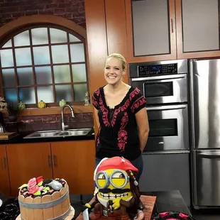a woman standing next to a cake