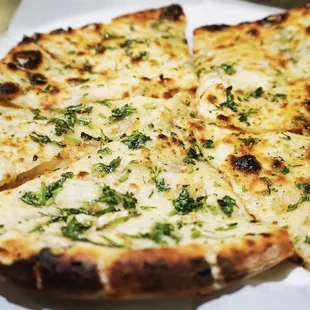 Disco Naan - Traditional Indian leavened bread stuffed with ginger, garlic, onions, and chillies topped off with cilantro and butter!