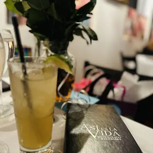 a glass of lemonade and a book on a table