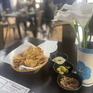 Basket with a mix of freshly made pita chips  and tortillas chips .Served  with home made hummus, olive's  and salsa.