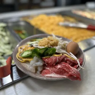 a plate of raw meat and vegetables
