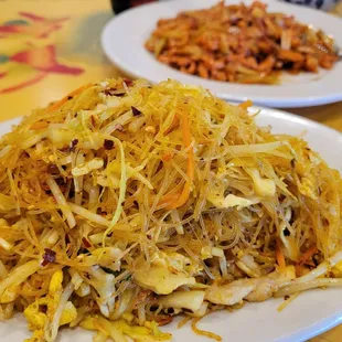 Singapore fried rice noodle with chicken and pork. Chicken and garlic dish in the background.