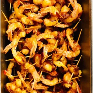 a bowl of shrimp skewered with toothpicks