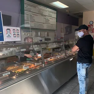 a man standing in front of a food counter
