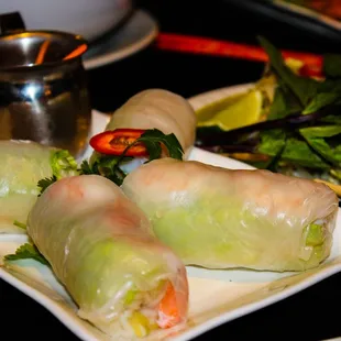 a plate of vietnamese food with a salad and dipping sauce