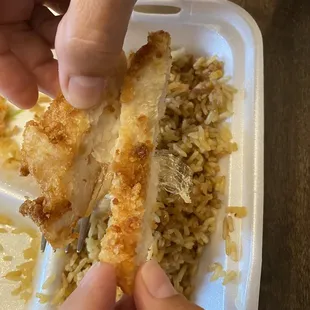 a person taking a piece of food out of a styrofoam container