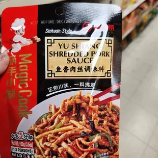 a hand holding a packet of noodles