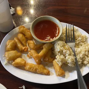 a plate of food with rice and dipping sauce