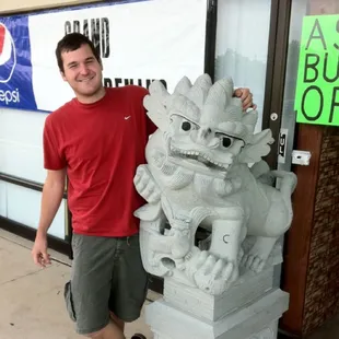 a man standing next to a statue