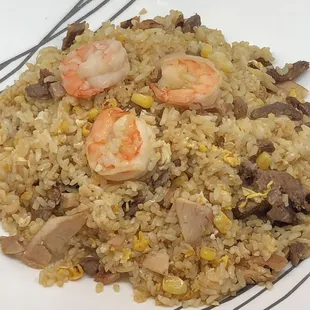 a plate of fried rice with shrimp and mushrooms
