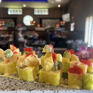 Season roll Cucumber,asparagus,avocado and cream cheese. Topped with pineapple,mango,tobiko and mango sauce!!
