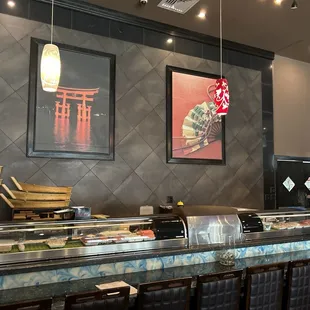 a sushi bar with a large picture on the wall