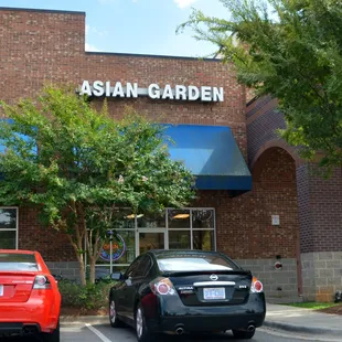 two cars parked in front of the asian garden