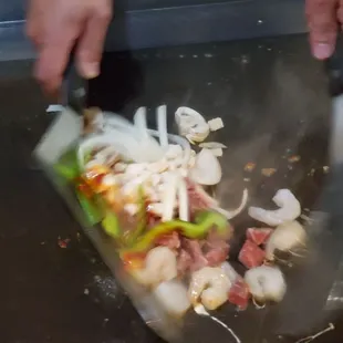 a person using a knife to cut vegetables