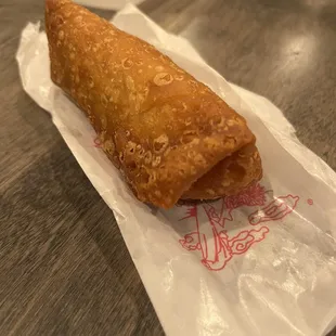 a fried pastry on a piece of wax paper