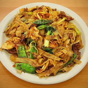 a plate of noodles with meat and vegetables