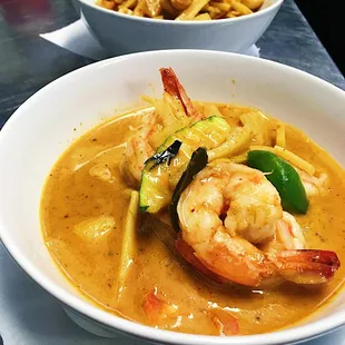 a bowl of soup with shrimp and vegetables