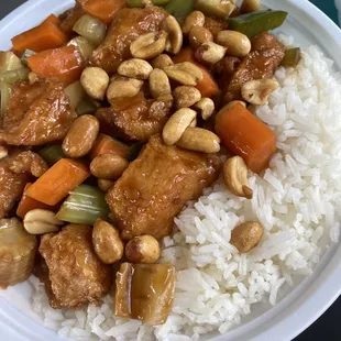 a plate of rice with chicken and vegetables