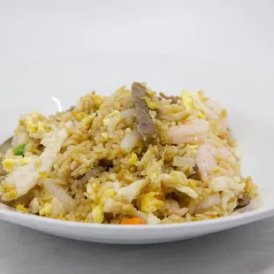 a plate of fried rice with shrimp and vegetables