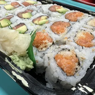 Avocado salmon roll and spicy salmon roll as part of a three roll lunch special takeout.
