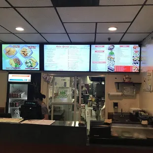 menus on multiple screens above counter