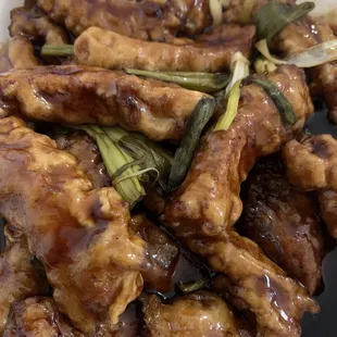 Sweet and sour pork ribs. No bones, some green onions, savory and sour.